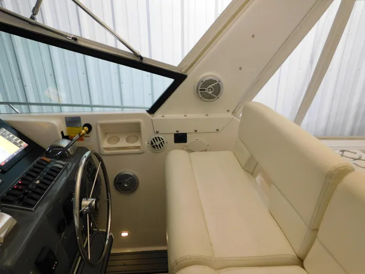 Sun Baked Yacht Photos Pics 1999 Tiara Yachts 3500 Express helm with steering wheel and white seating.