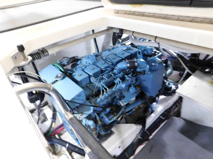 Sun Baked Yacht Photos Pics Engine compartment of a 1999 Tiara Yachts 3500 Express, showcasing a blue marine engine.