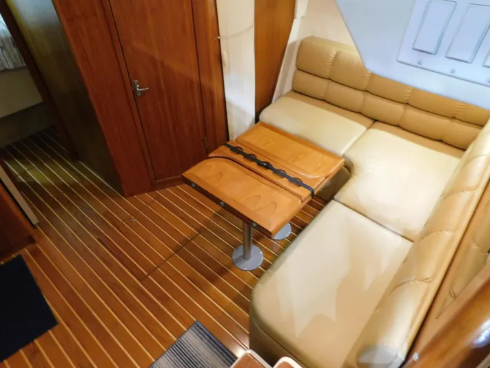Sun Baked Yacht Photos Pics 1999 Tiara Yachts 3500 Express interior with beige seating and wooden table.