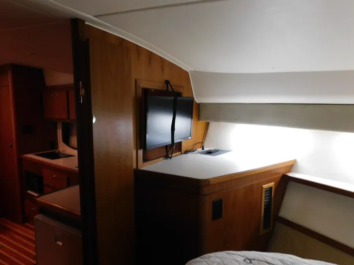 Sun Baked Yacht Photos Pics 1999 Tiara Yachts 3500 Express interior with wood cabinetry and mounted TV.
