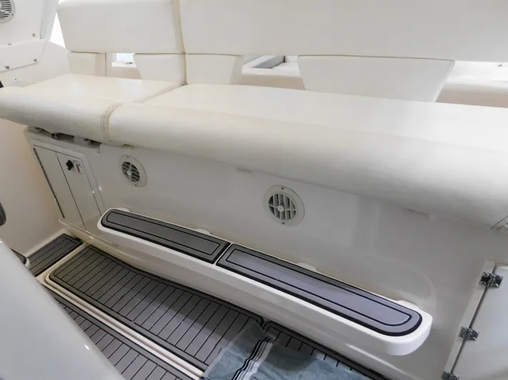 Sun Baked Yacht Photos Pics 1999 Tiara Yachts 3500 Express interior seating with white upholstery and storage compartments.