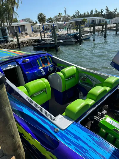  Yacht Photos Pics 2008 Outerlimits 39 Quattro speedboat with vibrant green and blue interior, docked by waterfront.