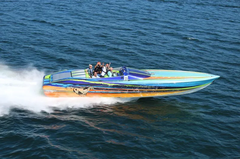  Yacht Photos Pics 2008 Outerlimits 39 Quattro speedboat racing on open water, vibrant design, multiple passengers.