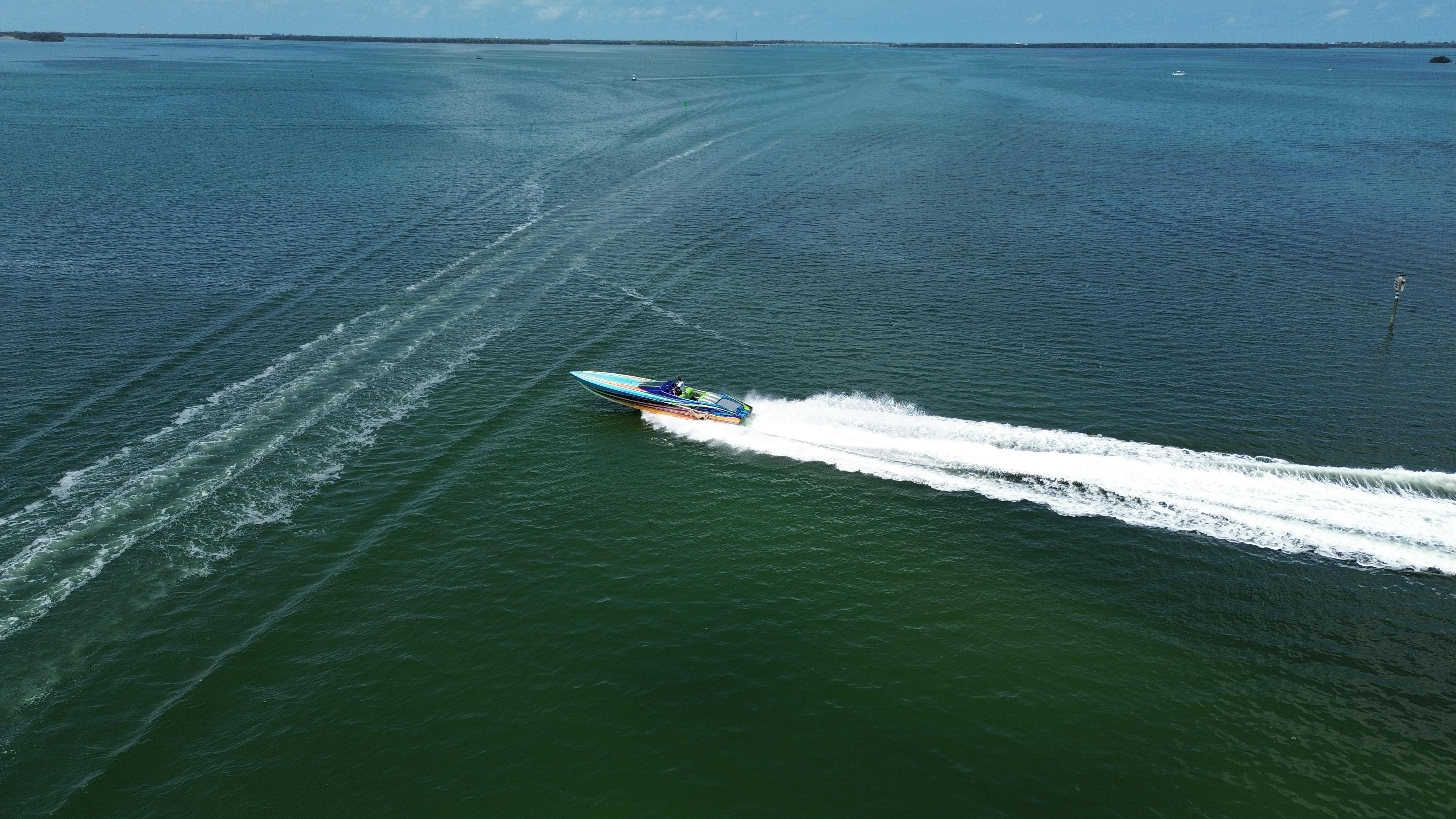 2008 Outerlimits 39 Quattro speedboat cruising on open water, leaving a white wake trail.
