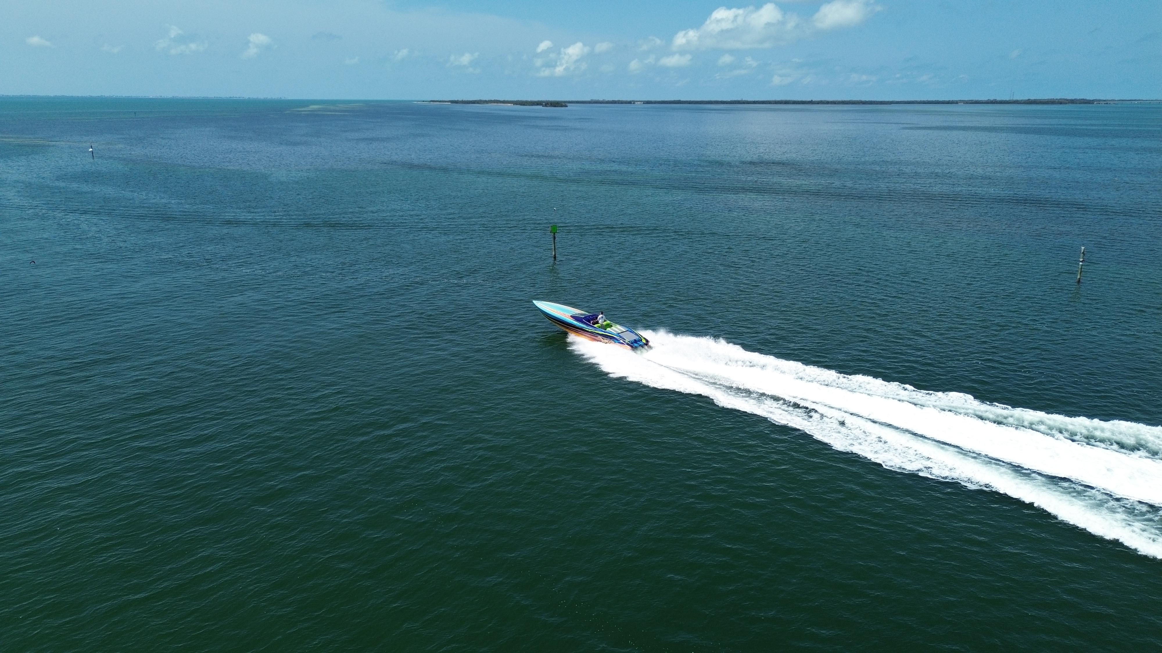 2008 Outerlimits 39 Quattro speedboat cruising on open water under a clear sky.