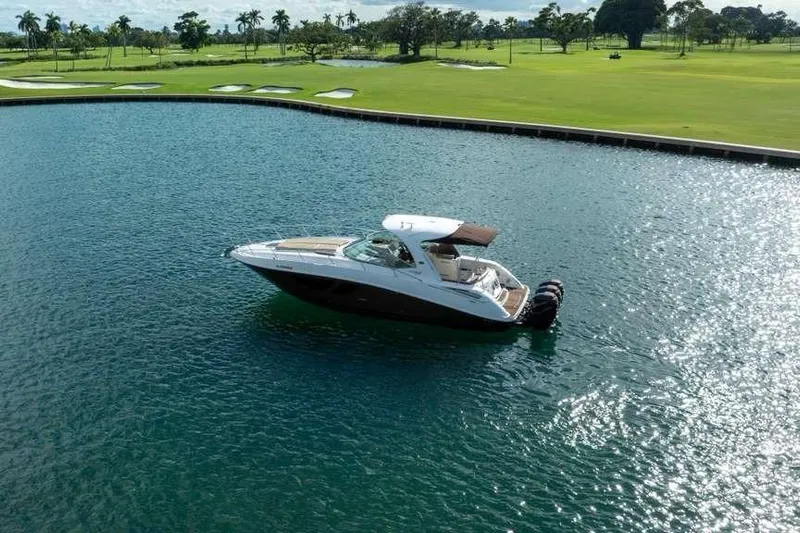  Yacht Photos Pics 2010 Sea Ray 370 Sundancer yacht on a serene lake near a golf course.