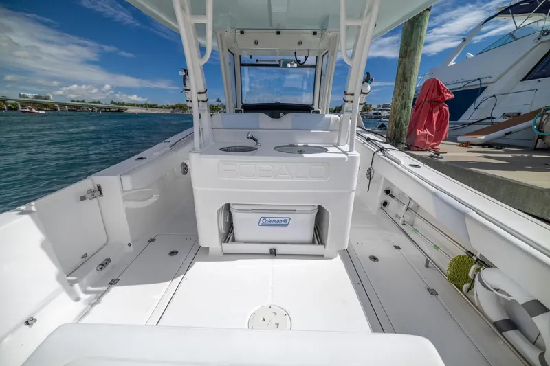  Yacht Photos Pics 2023 Robalo R302 Center Console boat interior at dock, featuring spacious deck and storage.