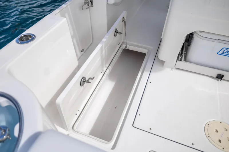  Yacht Photos Pics 2023 Robalo R302 Center Console boat storage compartment and seating area.