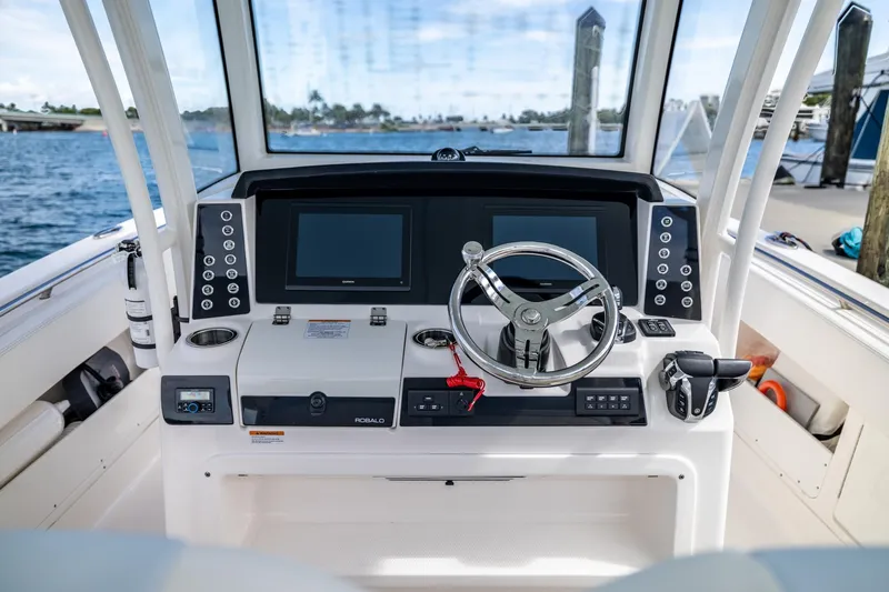  Yacht Photos Pics 2023 Robalo R302 Center Console boat helm with dual screens and steering wheel.