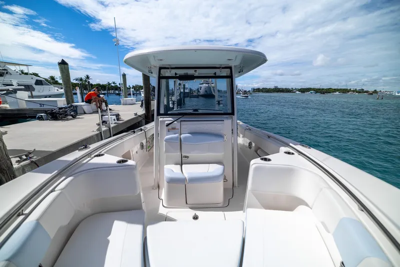  Yacht Photos Pics 2023 Robalo R302 Center Console boat docked, showcasing spacious seating and ocean view.