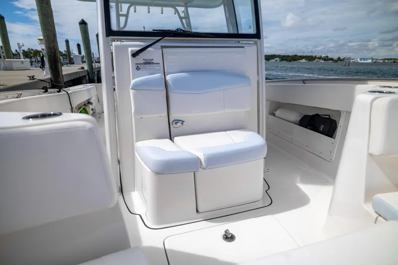  Yacht Photos Pics 2023 Robalo R302 Center Console boat interior with white seating and storage compartments.