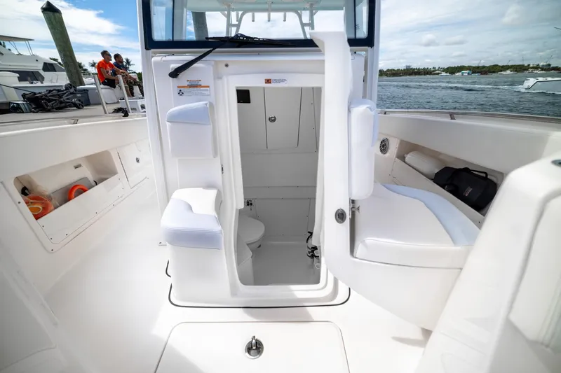  Yacht Photos Pics 2023 Robalo R302 Center Console boat interior with open cabin door and seating.