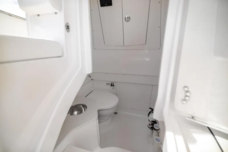  Yacht Photos Pics 2023 Robalo R302 Center Console boat interior with compact marine toilet.