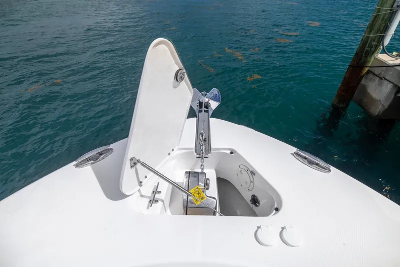  Yacht Photos Pics 2023 Robalo R302 Center Console boat anchor compartment open on calm water.