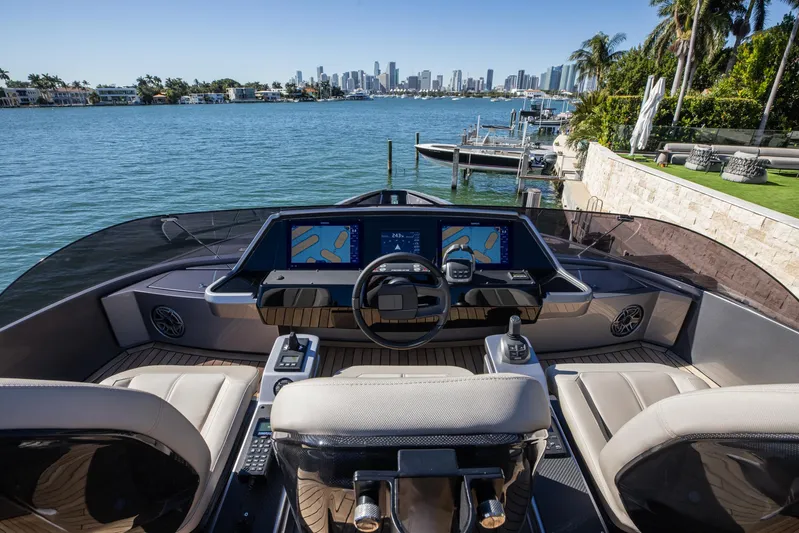  Yacht Photos Pics 2025 Pershing GTX 80 yacht cockpit with modern navigation screens, overlooking a scenic waterfront.