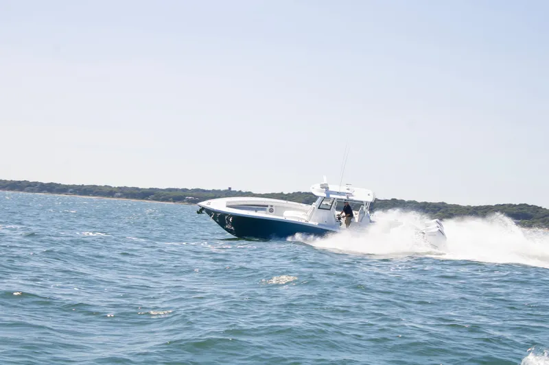  Yacht Photos Pics 2026 Yellowfin 36 Offshore boat speeding on open water near coastline.
