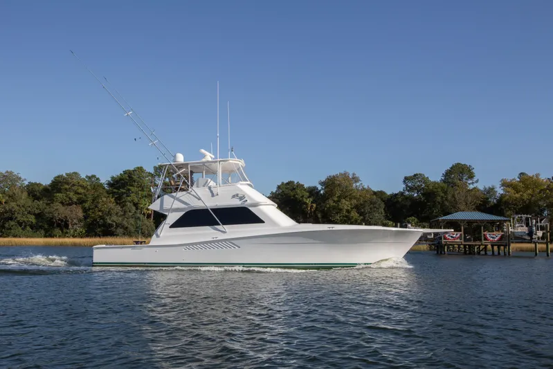 Lady S Yacht Photos Pics 2001 Viking 50 Convertible yacht cruising on a calm river under clear blue skies.