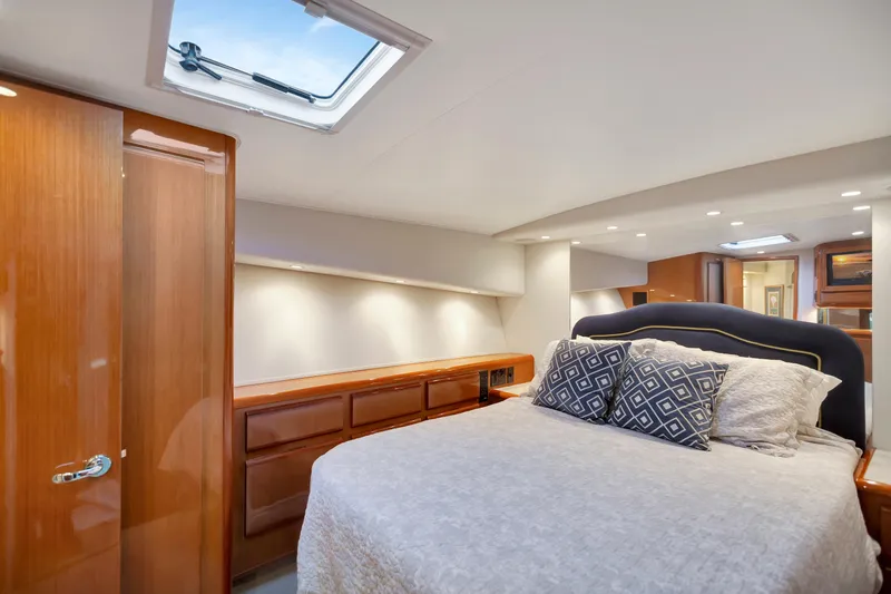Lady S Yacht Photos Pics Luxurious bedroom interior of 2001 Viking 50 Convertible yacht with elegant wood finishes.
