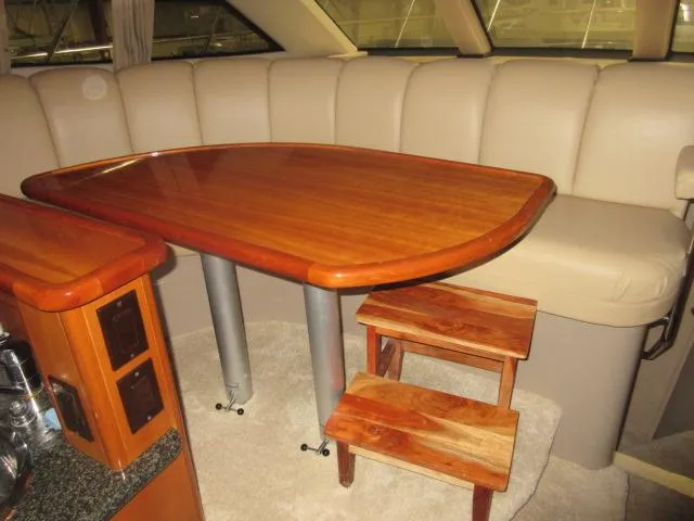  Yacht Photos Pics Interior dining area of 2005 Carver 36 Sport Sedan with wooden table and beige seating.