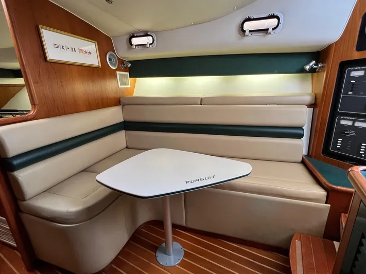  Yacht Photos Pics 1998 Pursuit 3400 Offshore DIESEL cabin with beige seating and wooden accents.