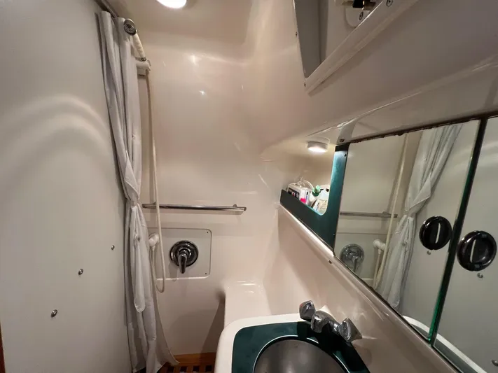  Yacht Photos Pics 1998 Pursuit 3400 Offshore DIESEL boat bathroom with shower, sink, and mirror.