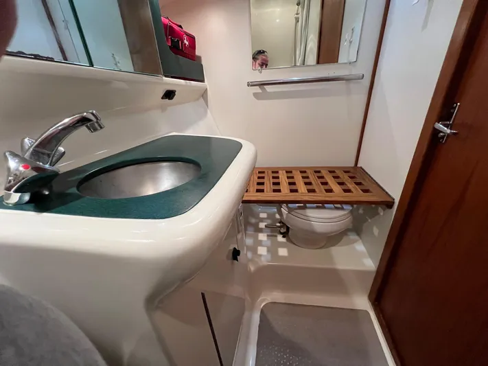  Yacht Photos Pics 1998 Pursuit 3400 Offshore DIESEL boat bathroom with sink, mirror, and wooden toilet cover.