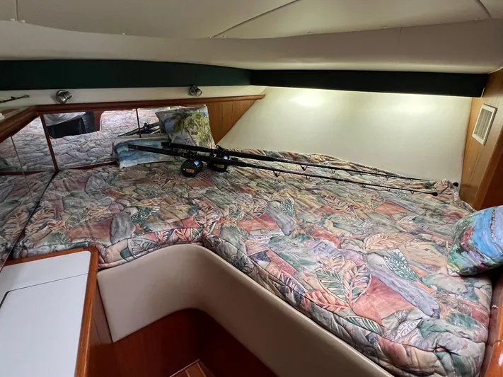  Yacht Photos Pics 1998 Pursuit 3400 Offshore DIESEL cabin with floral bedding and fishing rods.