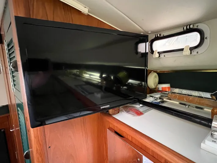  Yacht Photos Pics Interior of 1998 Pursuit 3400 Offshore with mounted Samsung TV and wooden cabinetry.
