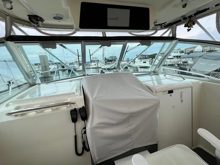  Yacht Photos Pics 1998 Pursuit 3400 Offshore DIESEL boat cockpit with covered controls, marina view in background.