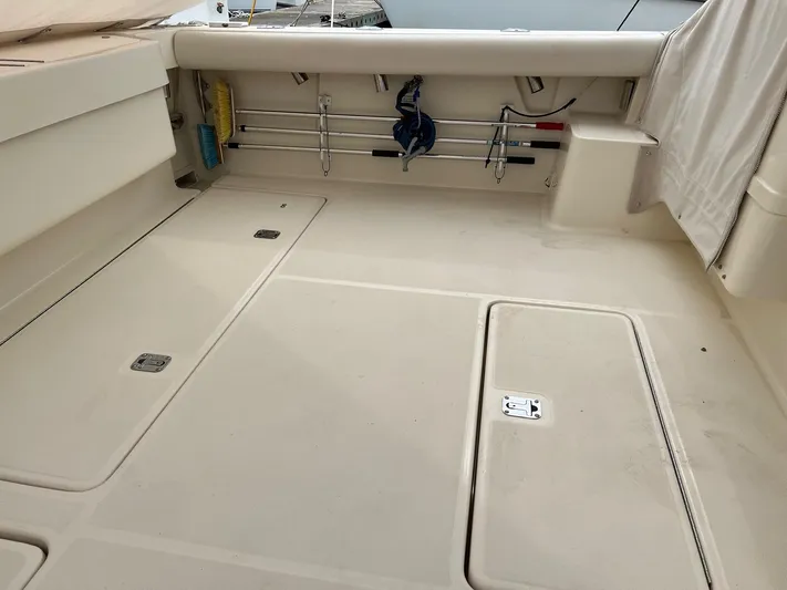  Yacht Photos Pics 1998 Pursuit 3400 Offshore DIESEL boat deck, featuring storage compartments and fishing rod holders.