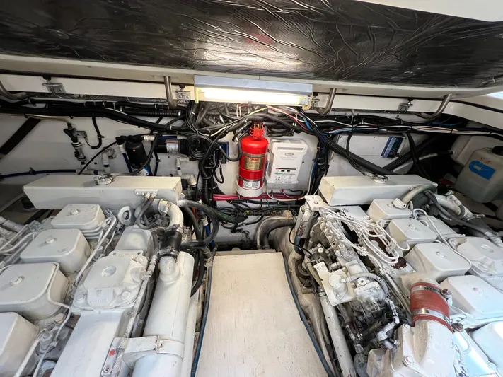  Yacht Photos Pics Engine room of a 1998 Pursuit 3400 Offshore DIESEL boat, showcasing dual engines and fire extinguisher.