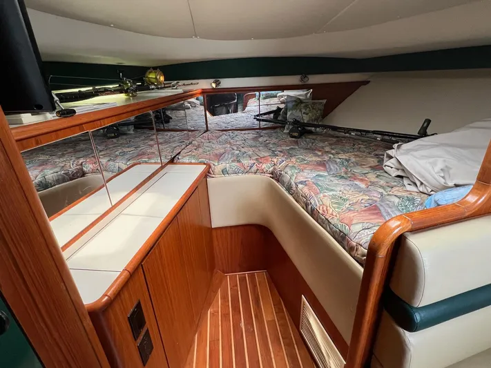  Yacht Photos Pics 1998 Pursuit 3400 Offshore DIESEL cabin with wood accents and patterned bedding.