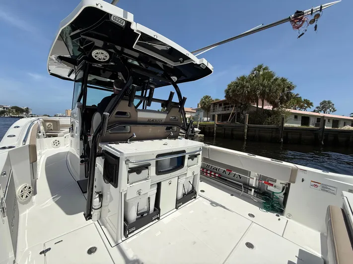 Sammy G Yacht Photos Pics 2020 Blackfin 332 CC boat with spacious deck and modern amenities, docked by waterfront homes.