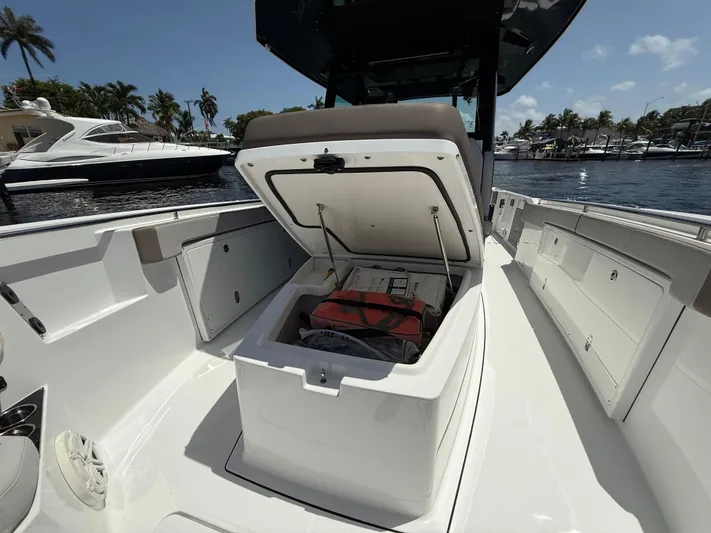 Sammy G Yacht Photos Pics 2020 Blackfin 332 CC boat with open storage compartment, docked near other boats.
