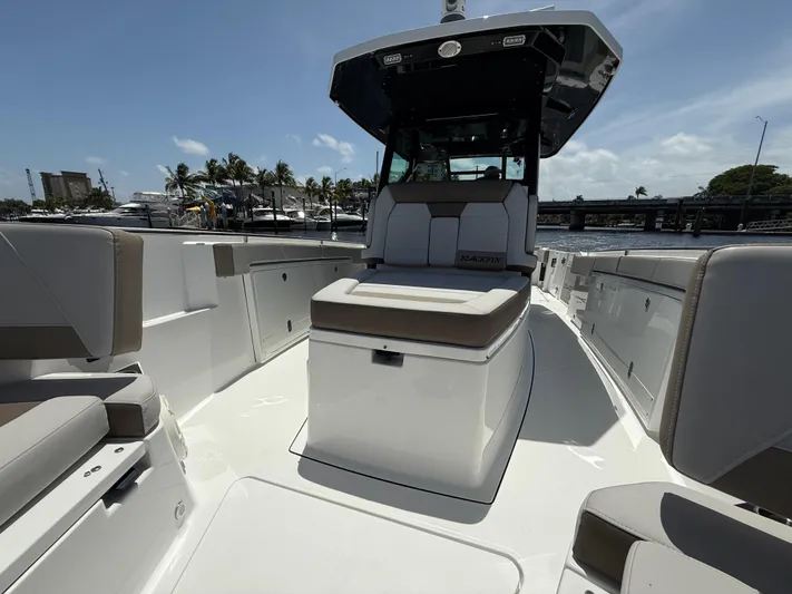 Sammy G Yacht Photos Pics 2020 Blackfin 332 CC boat interior with seating, docked near marina under clear sky.