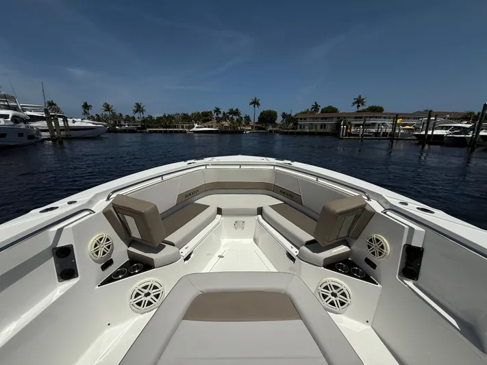 Sammy G Yacht Photos Pics 2020 Blackfin 332 CC boat interior with seating, speakers, and cup holders, docked in a marina.