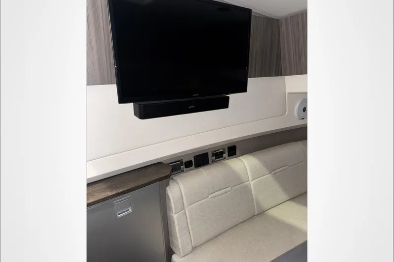  Yacht Photos Pics 2021 Sea Ray SLX 400 interior with TV, soundbar, and beige seating.