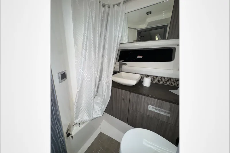  Yacht Photos Pics Modern bathroom interior of 2021 Sea Ray SLX 400 boat with sink and shower curtain.