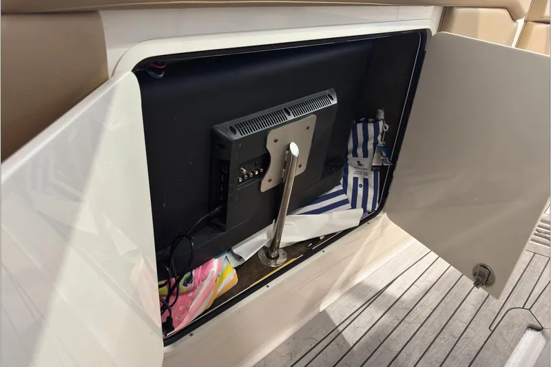  Yacht Photos Pics Open storage compartment on 2021 Sea Ray SLX 400 boat with TV and striped bag.