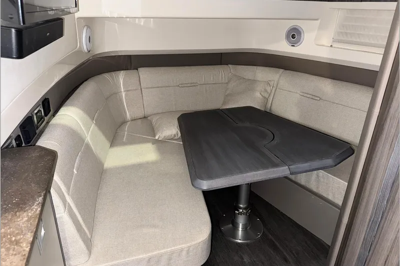  Yacht Photos Pics 2021 Sea Ray SLX 400 interior with beige seating and dark table.