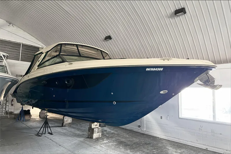  Yacht Photos Pics 2021 Sea Ray SLX 400 boat in storage, elevated on supports, inside a garage.