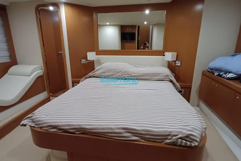  Yacht Photos Pics Luxurious bedroom interior of 2008 Ferretti Yachts 592 with striped bedding and wooden accents.