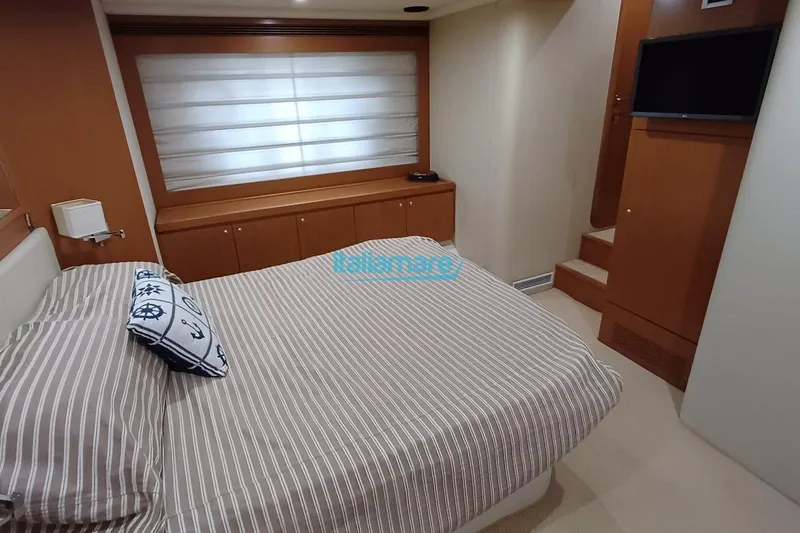  Yacht Photos Pics Luxurious bedroom interior of 2008 Ferretti Yachts 592 with striped bedding and nautical decor.