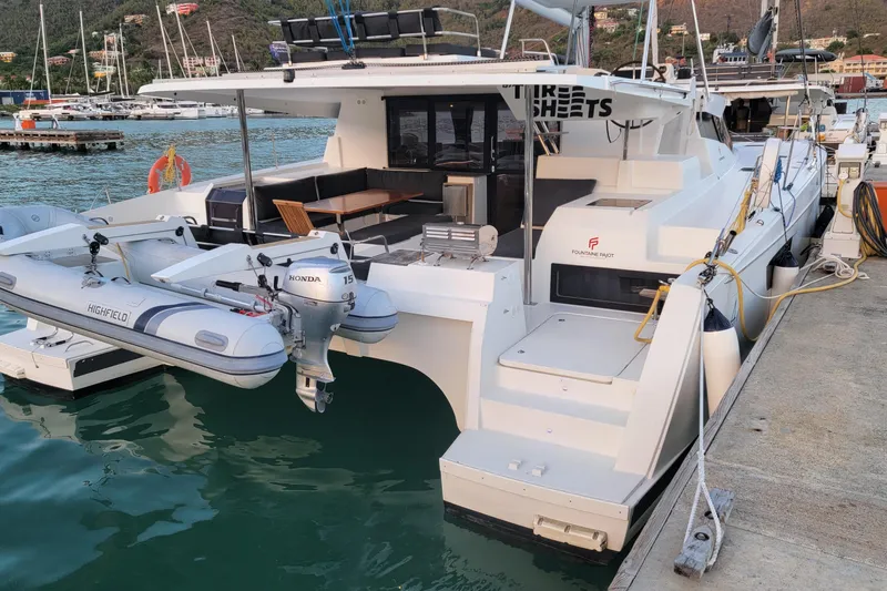 Three Sheets Yacht Photos Pics 2019 Fountaine Pajot Saona 47 catamaran docked with dinghy and scenic marina backdrop.