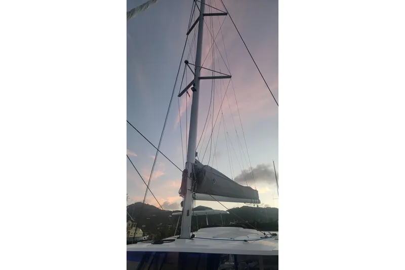 Three Sheets Yacht Photos Pics 2019 Fountaine Pajot Saona 47 sailboat mast at sunset, with scenic background.