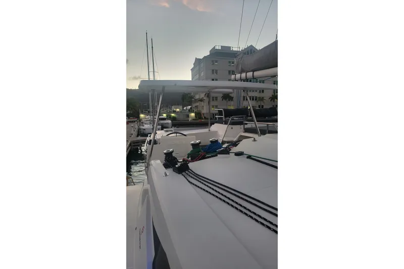 Three Sheets Yacht Photos Pics 2019 Fountaine Pajot Saona 47 catamaran docked at marina during sunset.