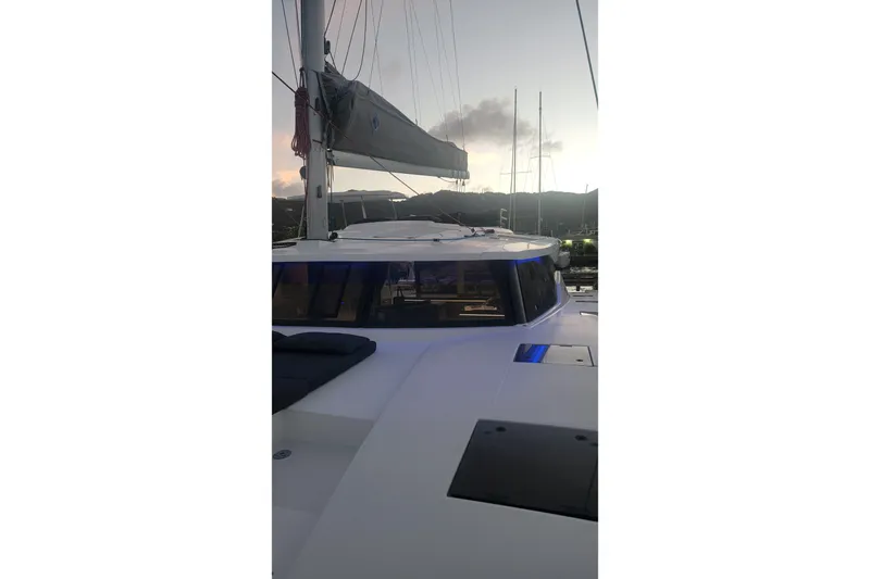 Three Sheets Yacht Photos Pics 2019 Fountaine Pajot Saona 47 catamaran at sunset, docked with sails down.