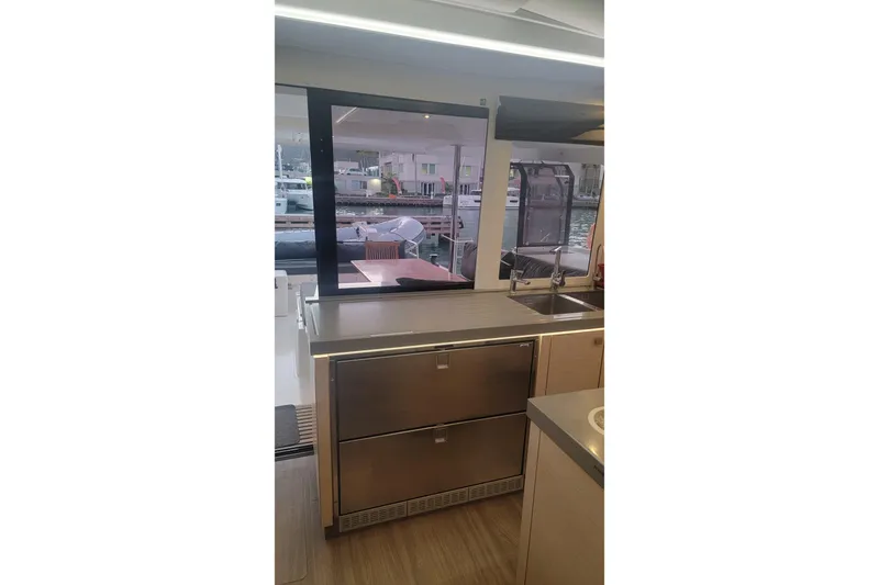 Three Sheets Yacht Photos Pics Modern kitchen interior of 2019 Fountaine Pajot Saona 47 yacht with stainless steel appliances.