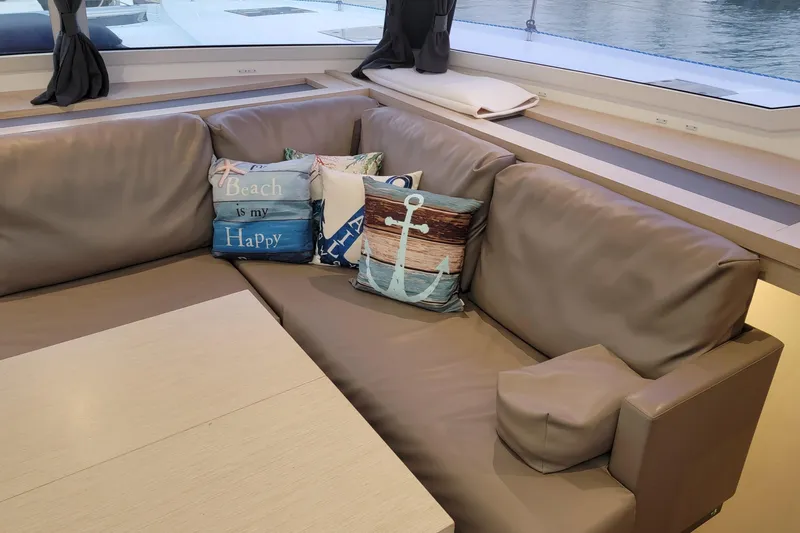 Three Sheets Yacht Photos Pics Luxurious interior of 2019 Fountaine Pajot Saona 47 with nautical-themed cushions.