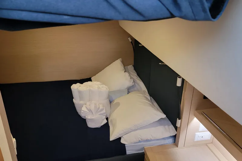 Three Sheets Yacht Photos Pics Cozy cabin interior of 2019 Fountaine Pajot Saona 47 with neatly arranged bedding.